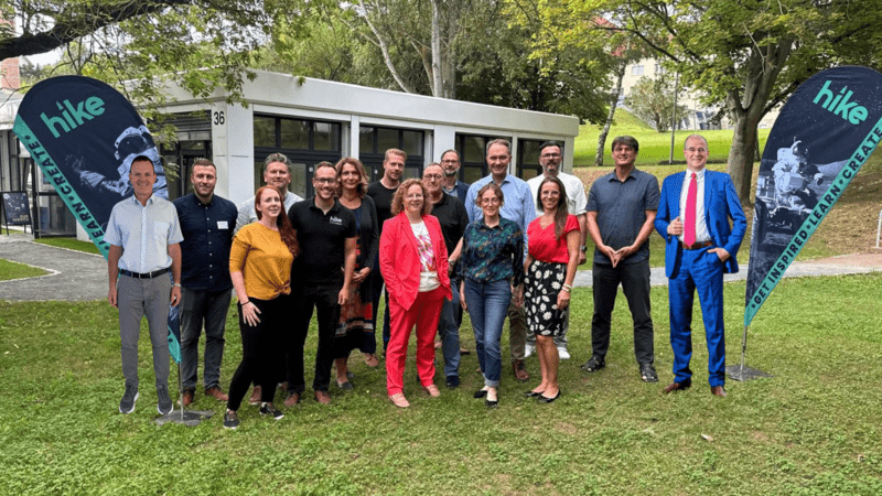 vor dem Hike Lab von links nach rechts: Prof. Dr. Jörg Wagner (HS NDH), Jonas Mielke (hike), Sharon Keegan (hike), Prof. Dr. Lutz Göcke (hike), Christian Zoll (hike), Jana Zöller (EVN), Wolf Goertz (Future Forest Initiative), Franziska Baum (MdL, FDP), Karl-Heinz Land (Neuland AI AG), Burkhard Zinner, Johanna Vargas (hike), Dr. Ralf Kuschnereit (Jenoptik AG), Dr. Kareen Schlangen (HS NDH), Thomas Herwig (HS NDH), Prof. Dr. Andreas Seidel (inklukids; HS NDH), Landrat Matthias Jendricke (LK Nordhausen); nicht auf dem Bild: Jakob Janssen (Readay; HS NDH), Thomas Fülder (Dori; HS NDH). (Foto: HSN | Fotomontage Landrat Jendricke © Marco Kneise)