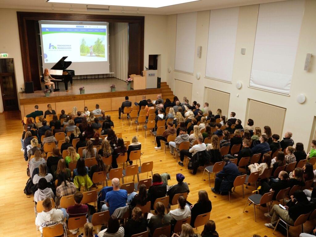 Blick von der Empore ins Audimax. Die frisch immatrikulierten Studierenden hören einer Rede zu.