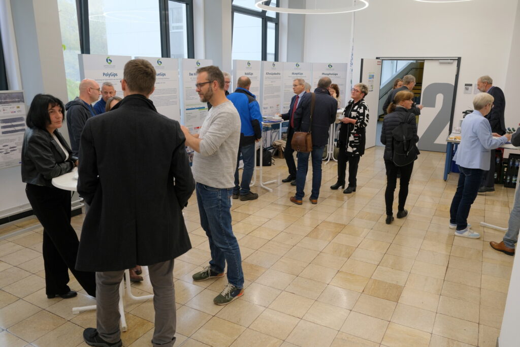 Gruppen von Menschen unterhalten sich im Foyer, vermutlich während einer Veranstaltungspause.